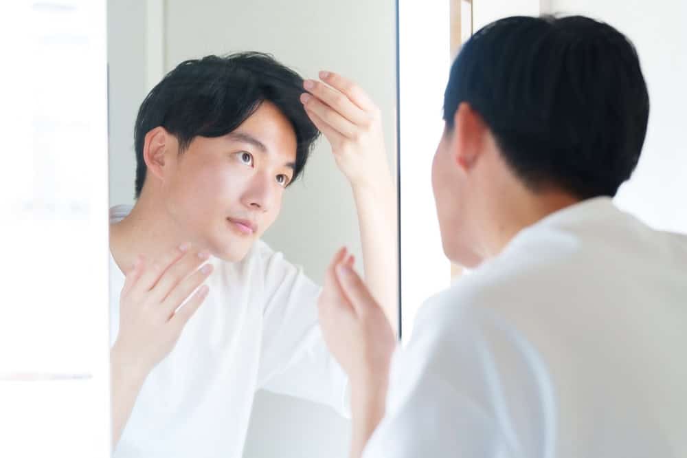 A man admires the results of taking vitamins for hair 